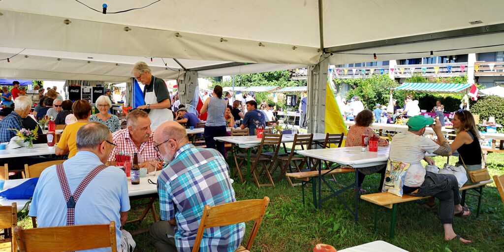 Leute sitzen am Mittag im Festzelt und essen und trinken