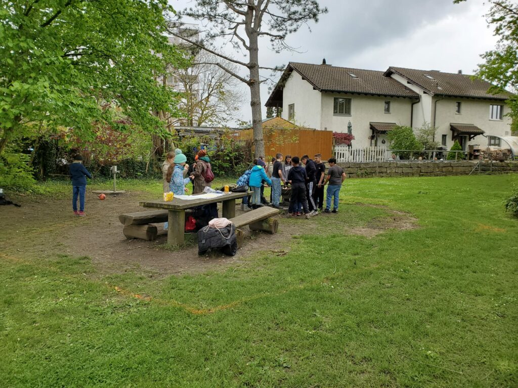 Ansicht des Grillplatzes vor zwei Wochen mit einigen Kindern, die um den Grill stehen